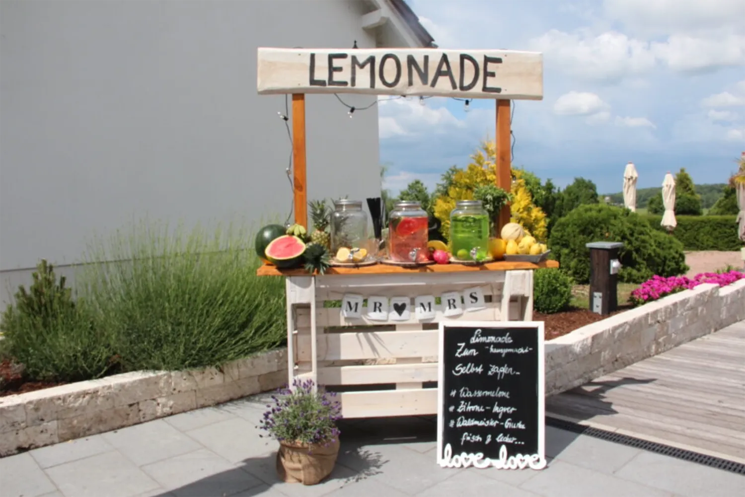 Liebevoll dekorierte Limonadenbar auf Hochzeit im Freien – sommerliches Hochzeitsdetail bei Feier mit DJ Dobbi