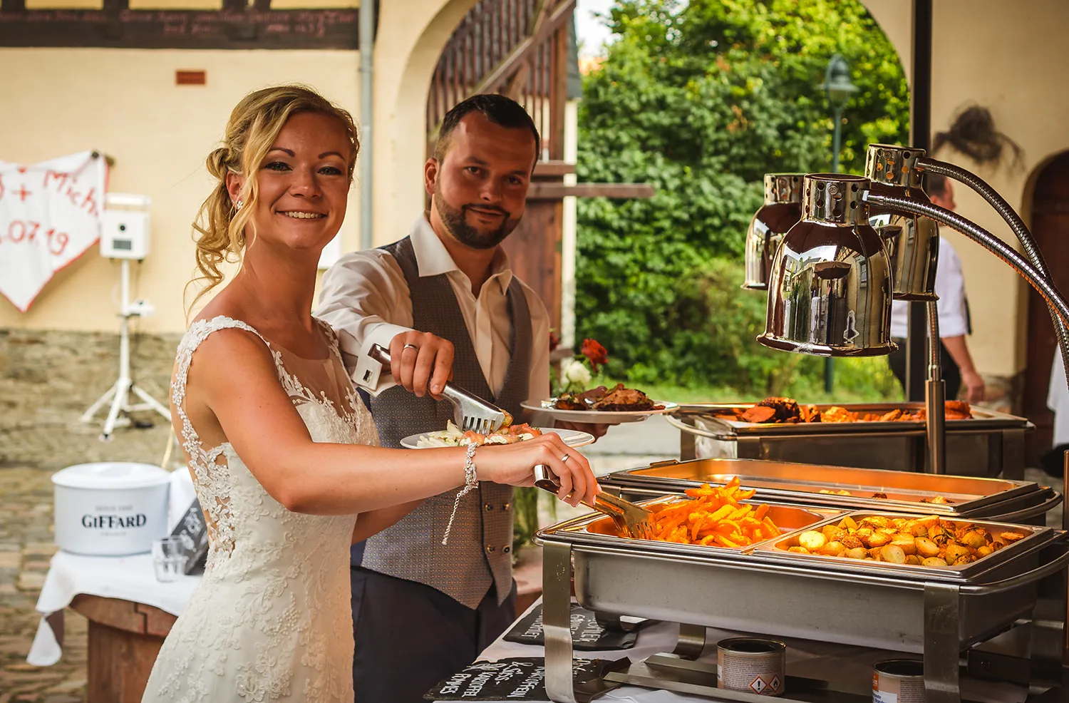 Brautpaar beim Hochzeitsbuffet unter freiem Himmel – festliche Feier mit DJ Dobbi und kulinarischem Genuss