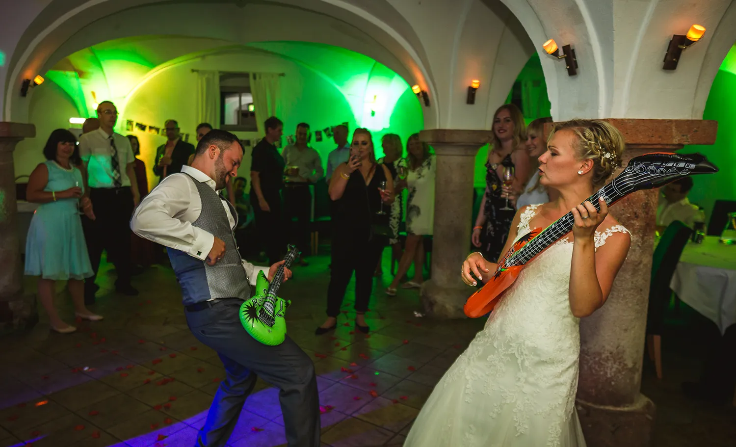 Braut und Bräutigam feiern ausgelassen mit Luftgitarren auf der Tanzfläche – Hochzeitsstimmung mit DJ Dobbi und Partyhits